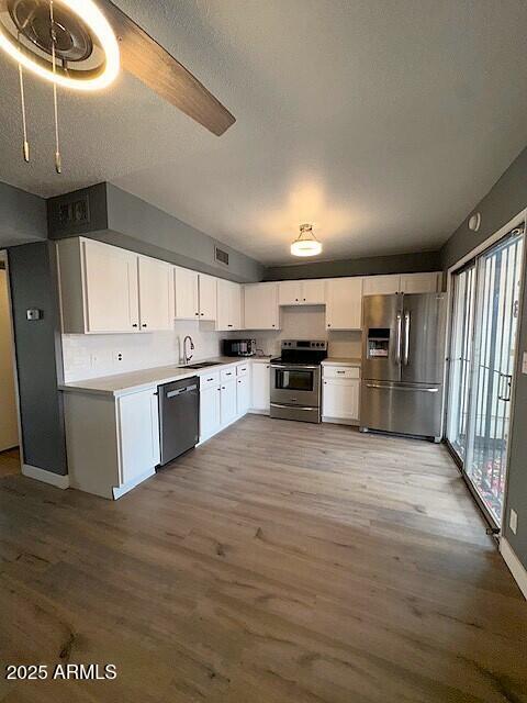 2551 West Berridge Lane, Unit D6 Phoenix, AZ 85017 - Photo 7 of 20 a large kitchen with stainless steel appliances granite countertop a lot of counter space and wooden floors