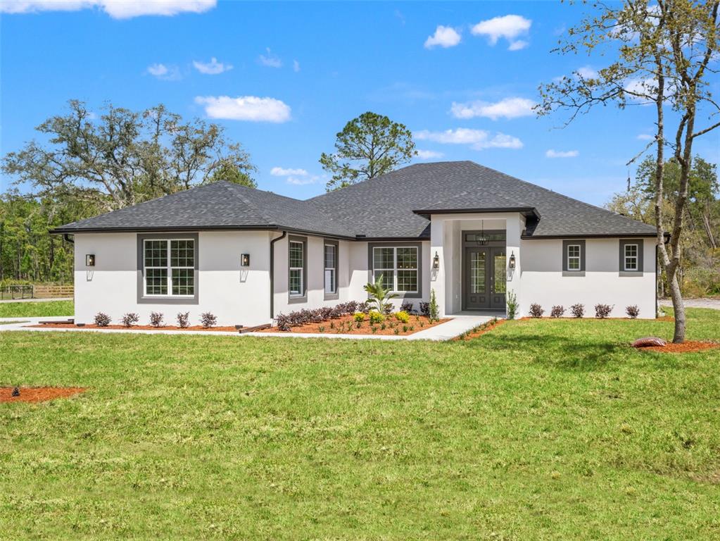 42430 Fir Street Eustis, FL 32736 - Photo 1 of 44 a front view of a house with a garden and porch