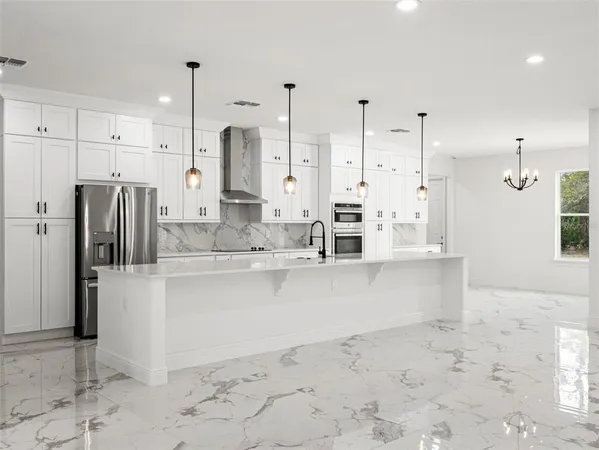 a kitchen with white cabinets and window