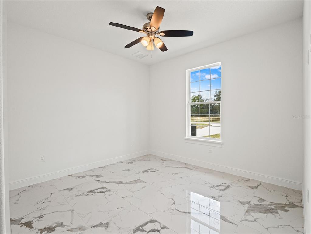 42430 Fir Street Eustis, FL 32736 - Photo 20 of 44 a view of a bedroom with a window and a ceiling fan