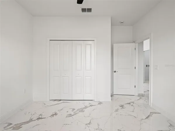 an empty room with a window and a fan