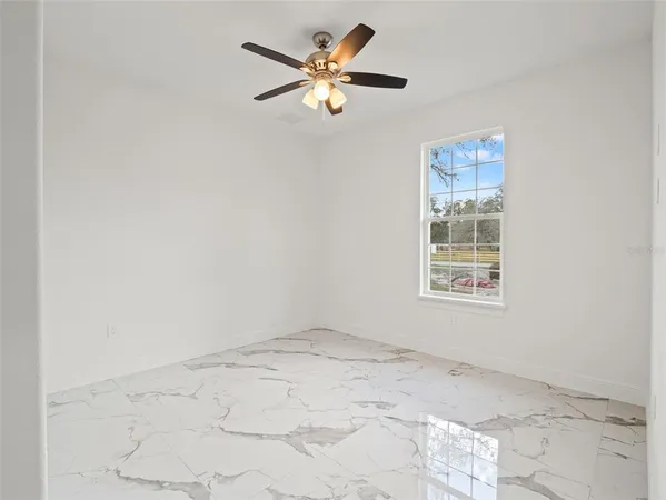 a view of a livingroom with a ceiling fan and window
