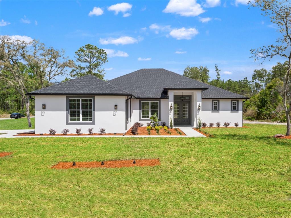 42430 Fir Street Eustis, FL 32736 - Photo 3 of 44 a front view of a house with a garden and porch