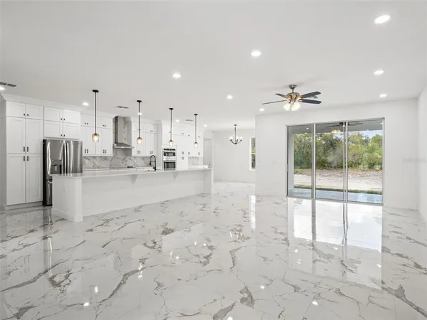 a view of kitchen with kitchen island stainless steel appliances refrigerator sink and cabinets