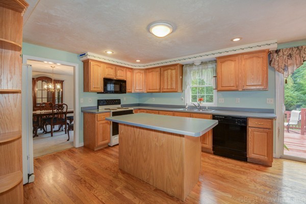 5 Garrison Road Shirley, MA 01464 - Photo 8 of 29 a kitchen with stainless steel appliances granite countertop a stove top oven a sink dishwasher a dining table and chairs with wooden floor