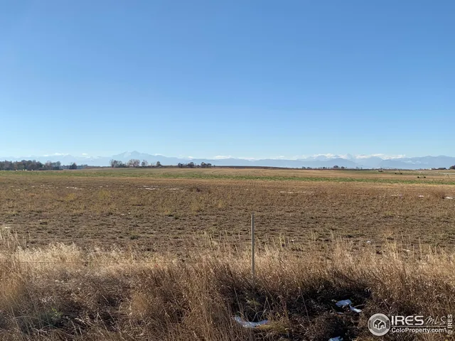 a view of a lake with beach and city in the back