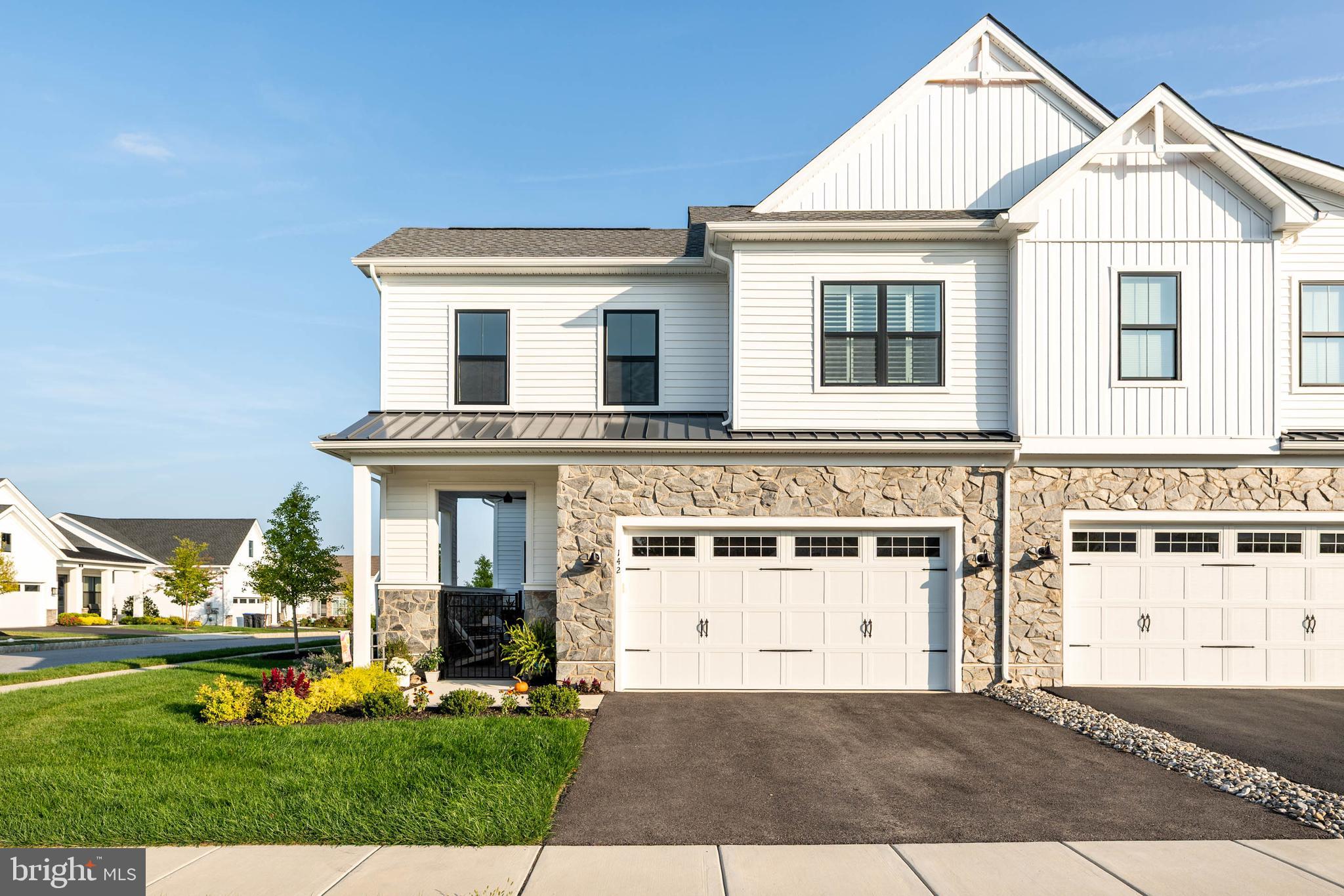 a view of a white house with a big yard and potted plants