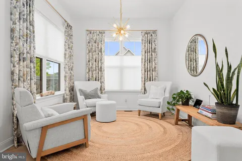 a living room with furniture a chandelier and a large mirror