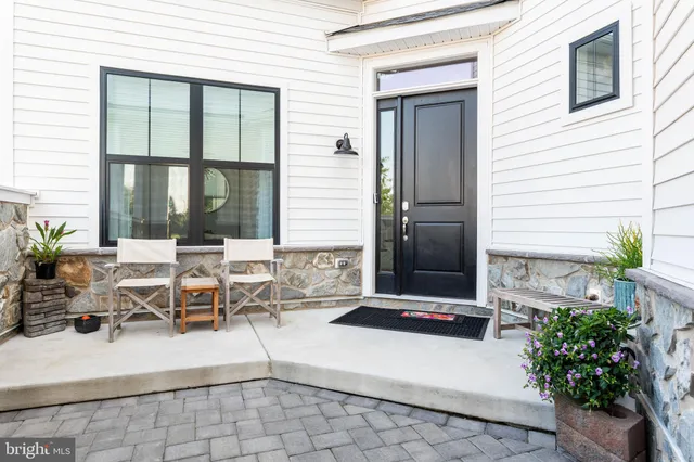 a living room with patio furniture and potted plants