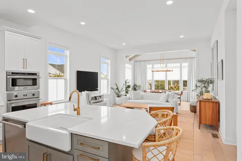 a living room with furniture a flat screen tv and a large window