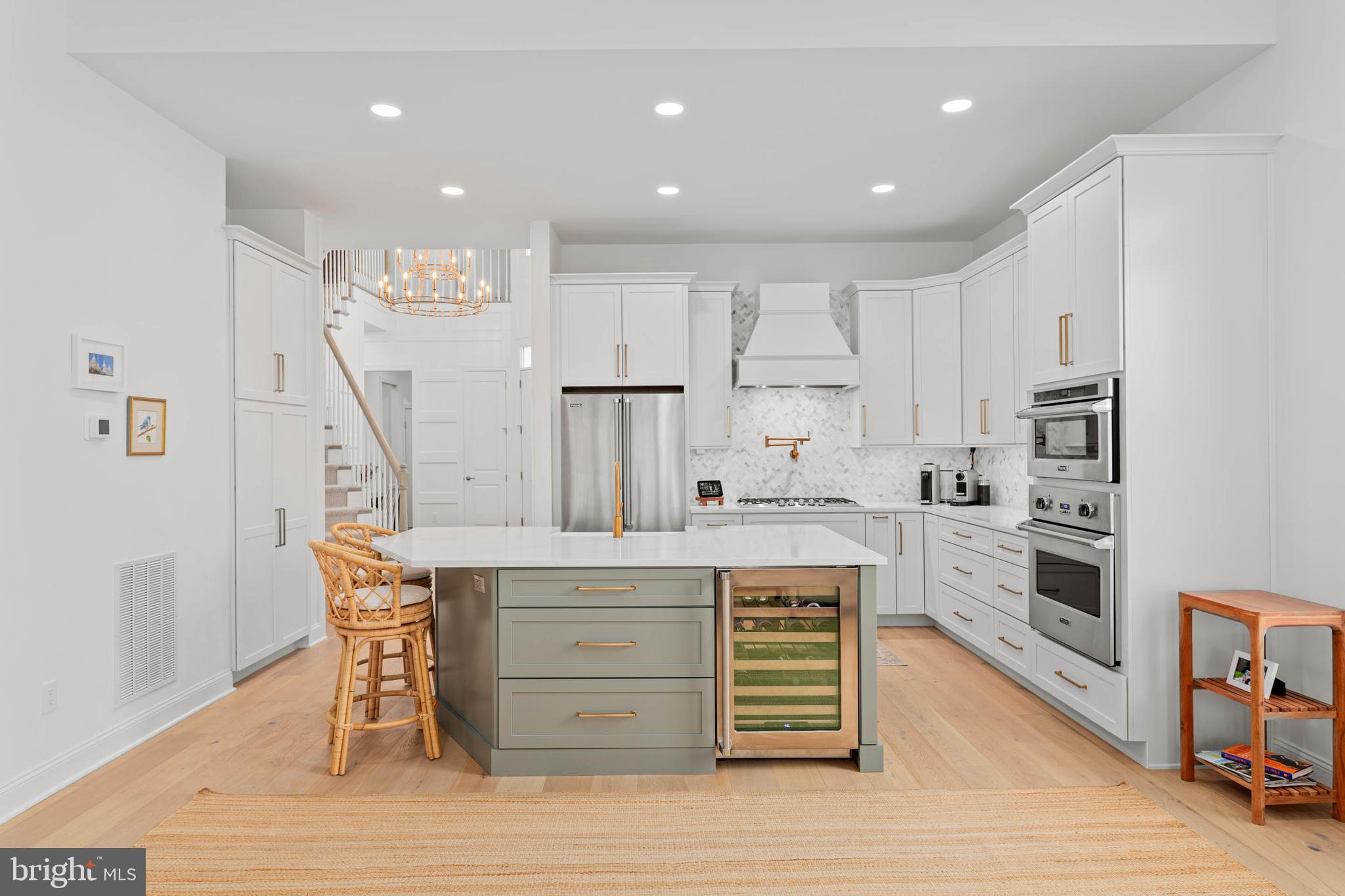 142 Preakness Way Downingtown, PA 19335 - Photo 10 of 56 a kitchen with stainless steel appliances kitchen island granite countertop a stove a refrigerator and white cabinets with wooden floor
