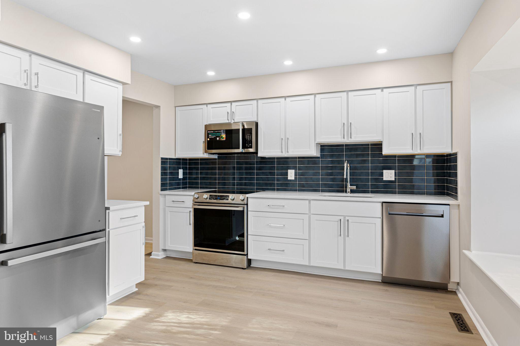 a kitchen with stainless steel appliances a refrigerator sink and stove