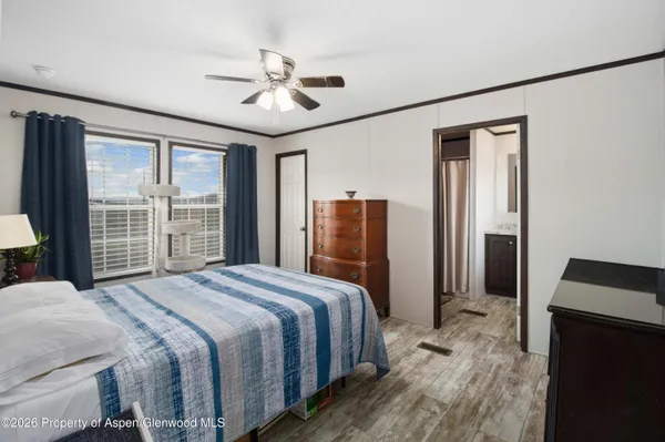 a bedroom with a large bed and a flat tv screen