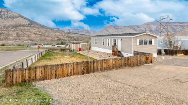 a view of a house with wooden fence