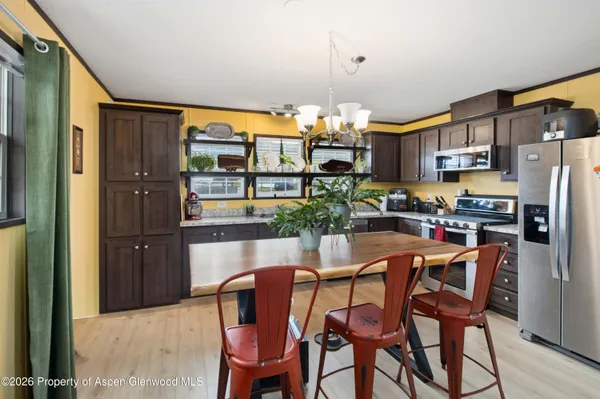 a dining room with stainless steel appliances a table and chairs