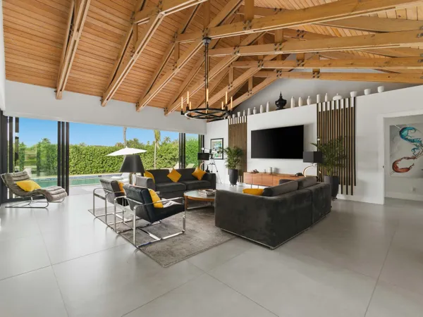 a living room with furniture a chandelier and a large window