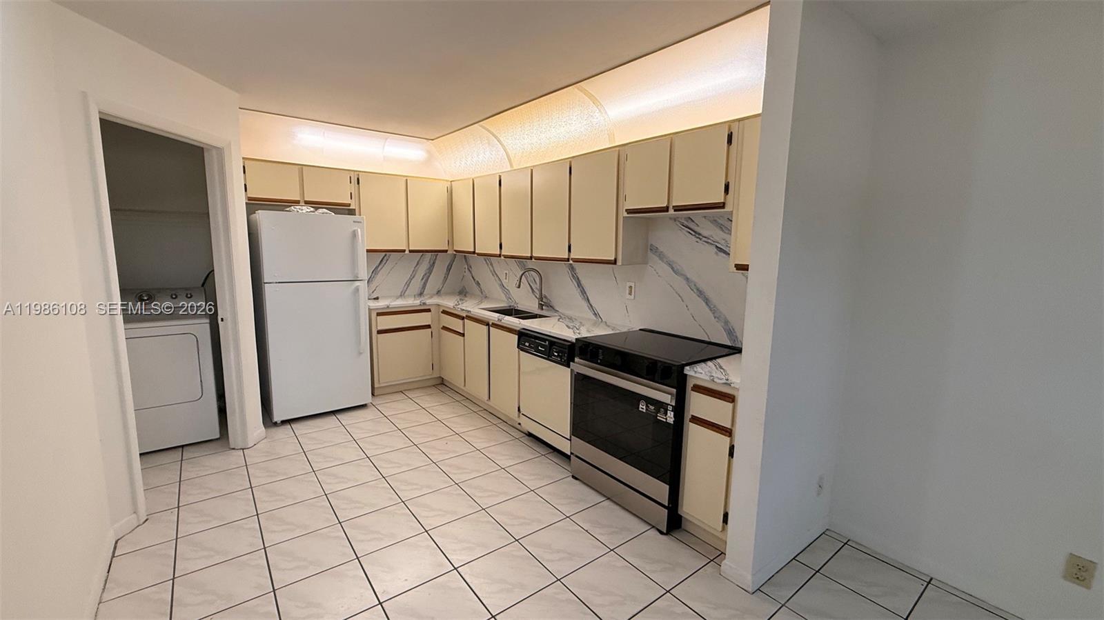 513 Racquet Club Road, Unit 55 Weston, FL 33326 - Photo 24 of 25 a kitchen with granite countertop a refrigerator and a stove top oven