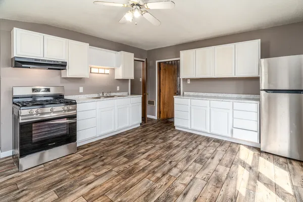 a kitchen with stainless steel appliances a stove a sink and a refrigerator