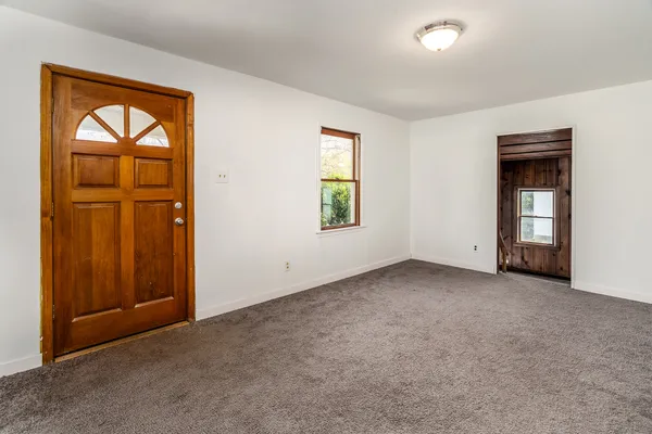 an empty room with windows and closet