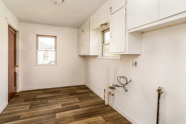 a view of a room with wooden floor and cabinets