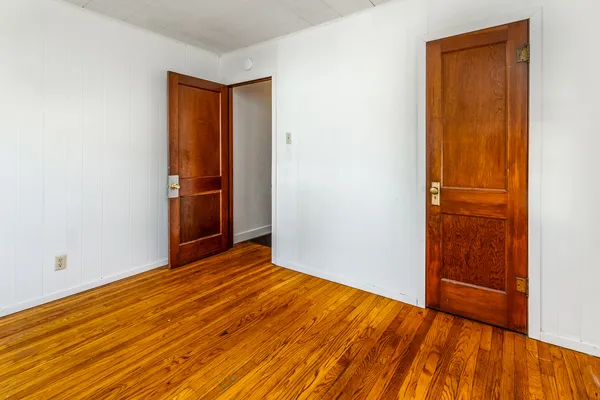 an empty room with wooden floor and closet