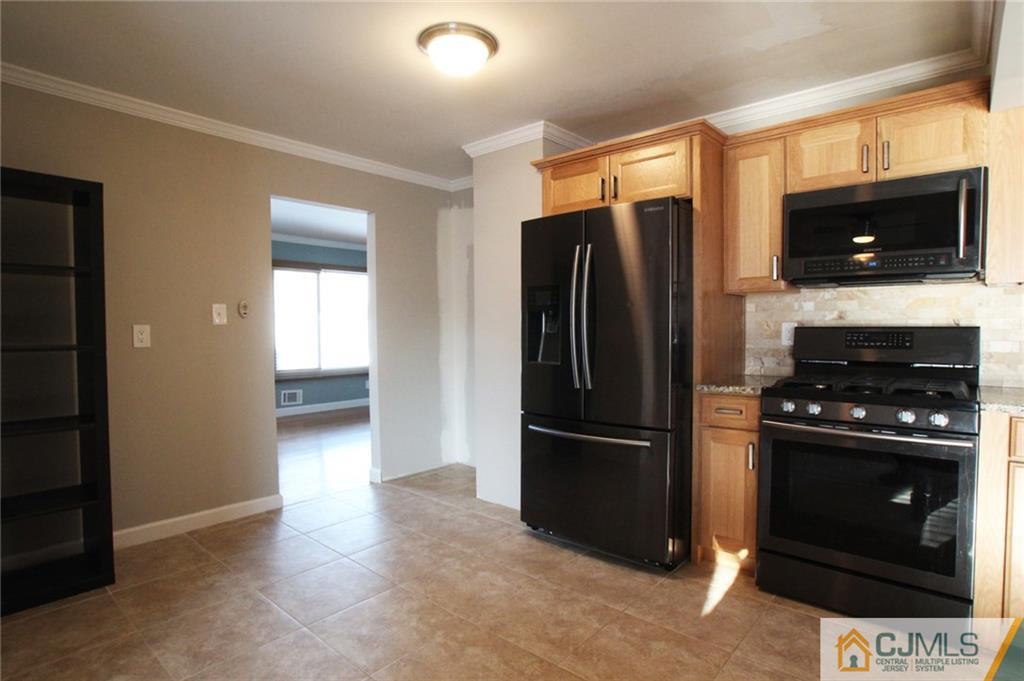 13 Racetrack Road East Brunswick, NJ 08816 - Photo 3 of 15 a kitchen with a refrigerator stove and microwave