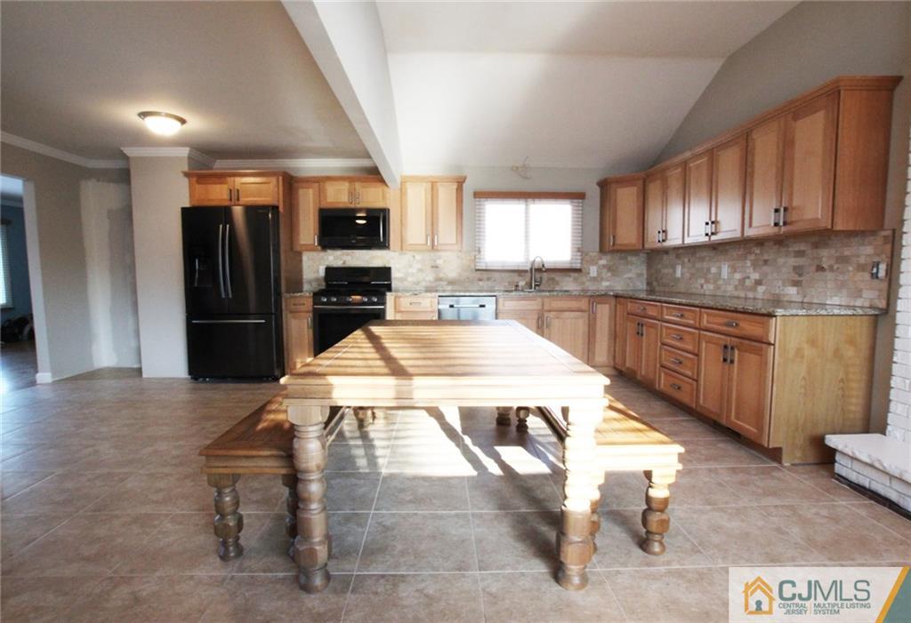 13 Racetrack Road East Brunswick, NJ 08816 - Photo 4 of 15 a kitchen with a stove a refrigerator and cabinets