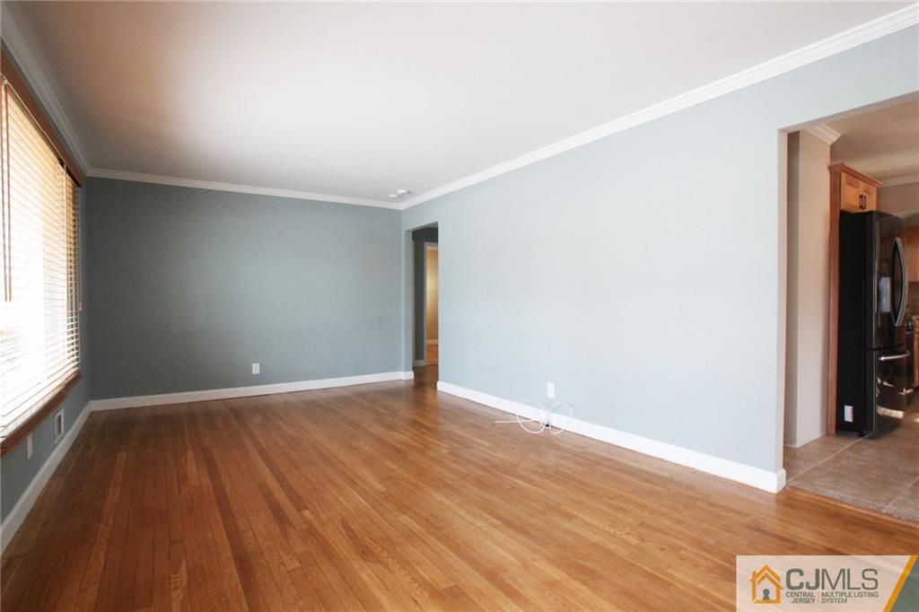 13 Racetrack Road East Brunswick, NJ 08816 - Photo 7 of 15 an empty room with wooden floor and a window