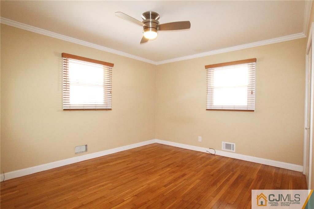 13 Racetrack Road East Brunswick, NJ 08816 - Photo 8 of 15 a view of a room with wooden floor and a ceiling fan