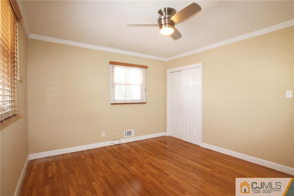 13 Racetrack Road East Brunswick, NJ 08816 - Photo 10 of 15 a view of empty room with wooden floor and fan
