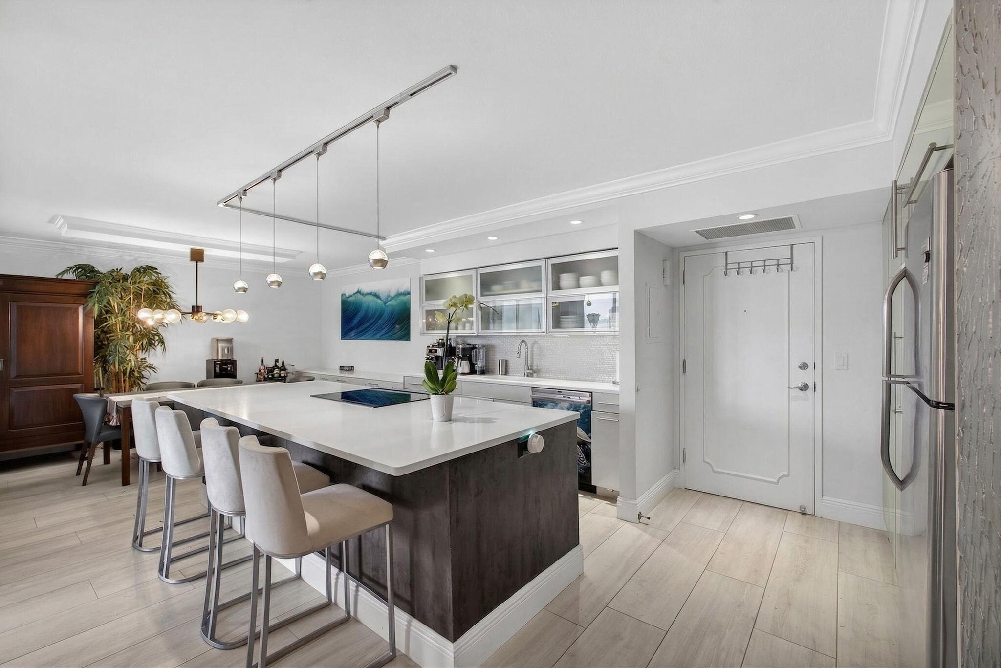 5440 North Ocean Drive, Unit 805 Singer Island, FL 33404 - Photo 1 of 56 a kitchen with a table chairs refrigerator and wooden floor