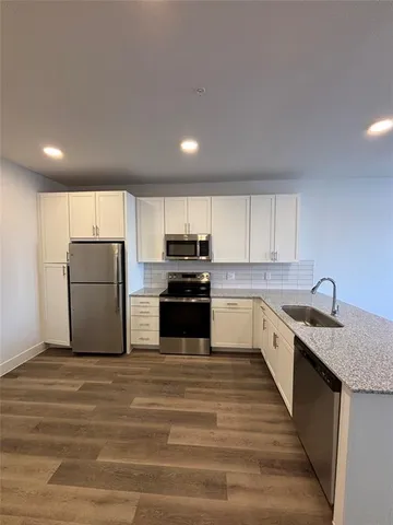 a kitchen with a refrigerator and a stove top oven
