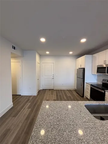 a view of a kitchen with a sink and a refrigerator
