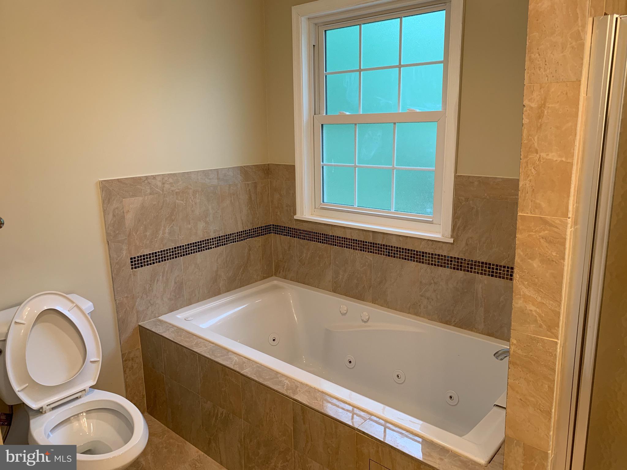 9700 Brookford Road Potomac, MD 20854 - Photo 15 of 27 a bathroom with a bathtub and window
