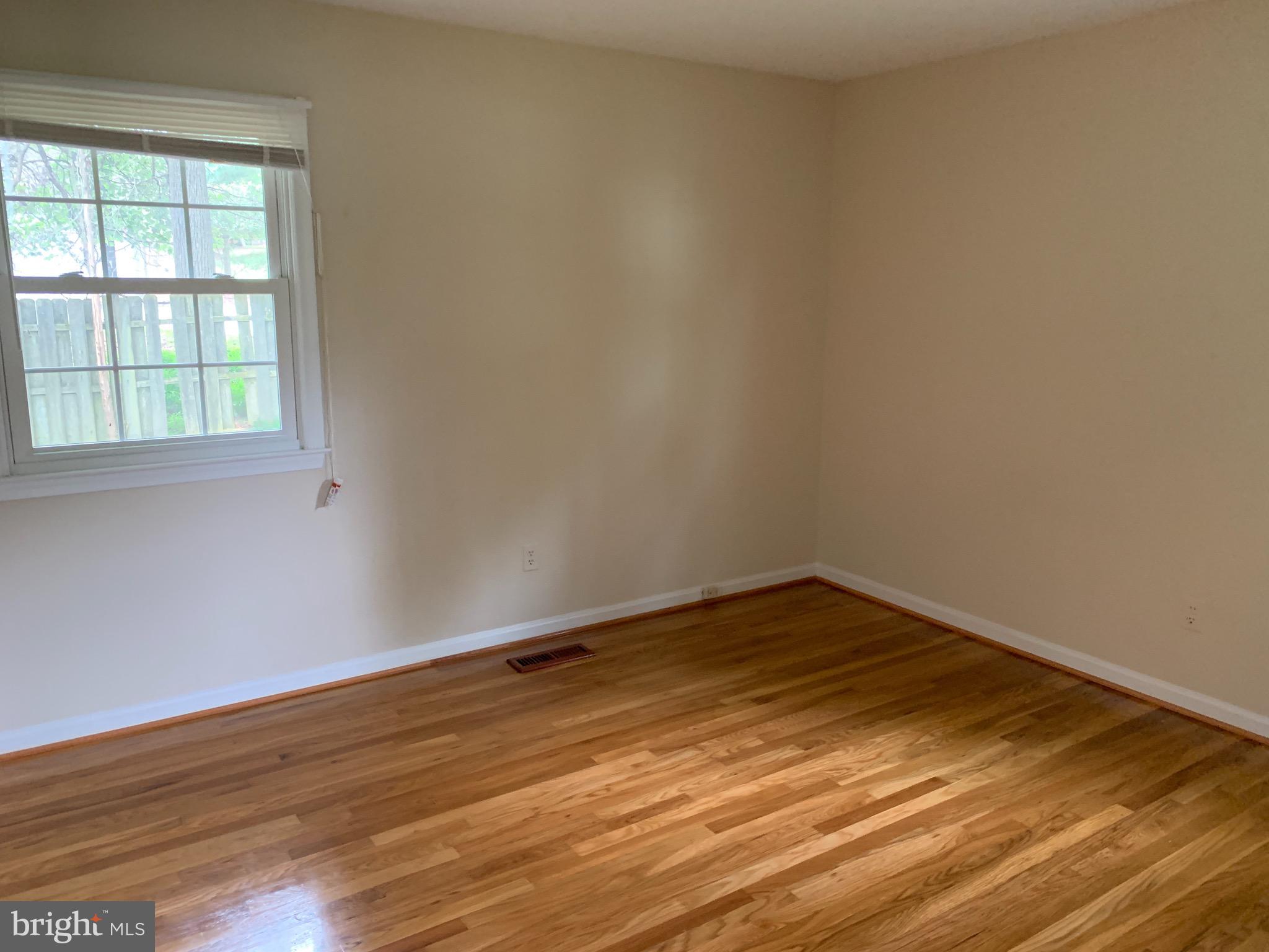 9700 Brookford Road Potomac, MD 20854 - Photo 18 of 27 a view of an empty room with wooden floor and a window