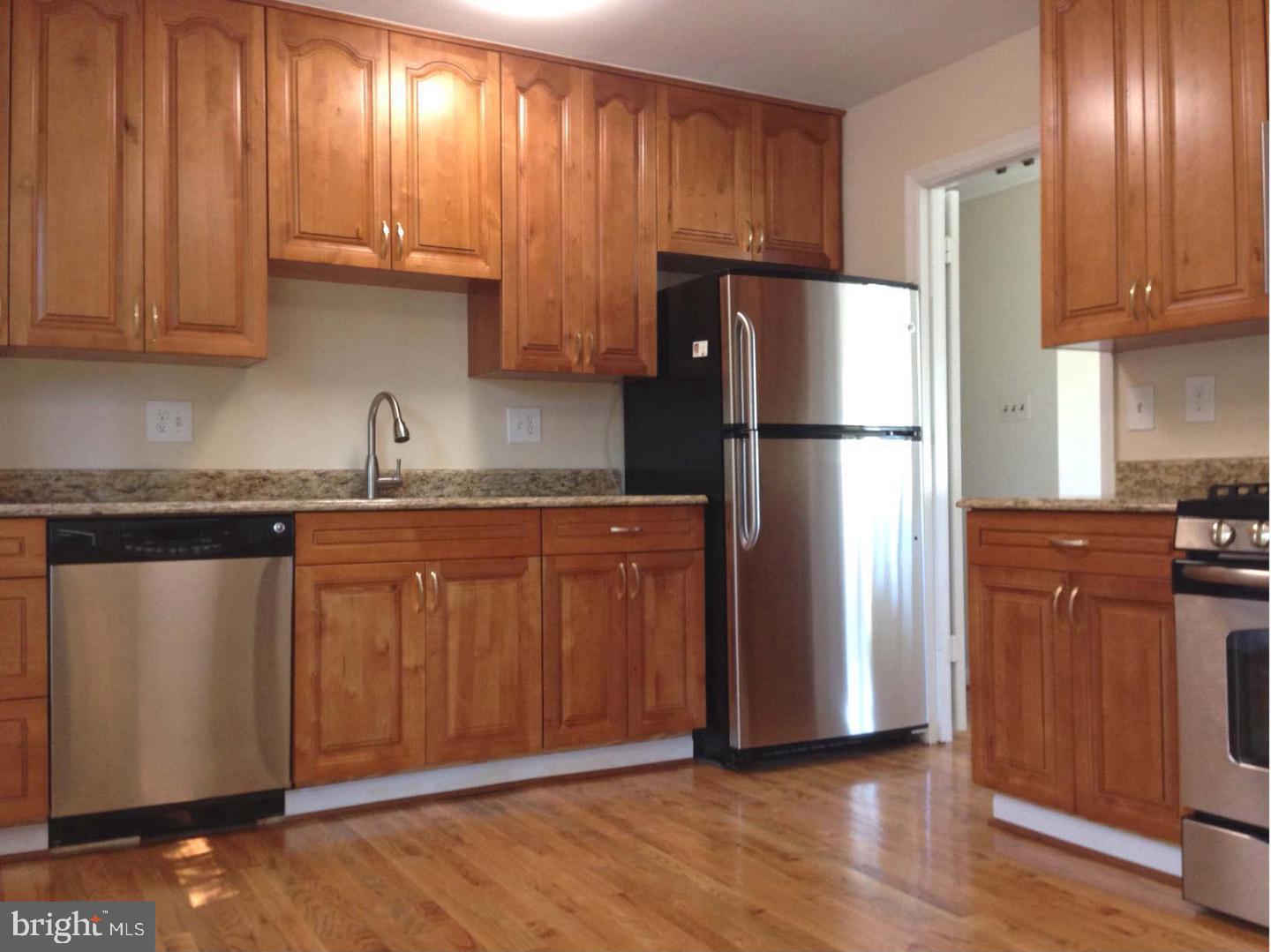 9700 Brookford Road Potomac, MD 20854 - Photo 3 of 27 a kitchen with granite countertop wooden cabinets and refrigerator