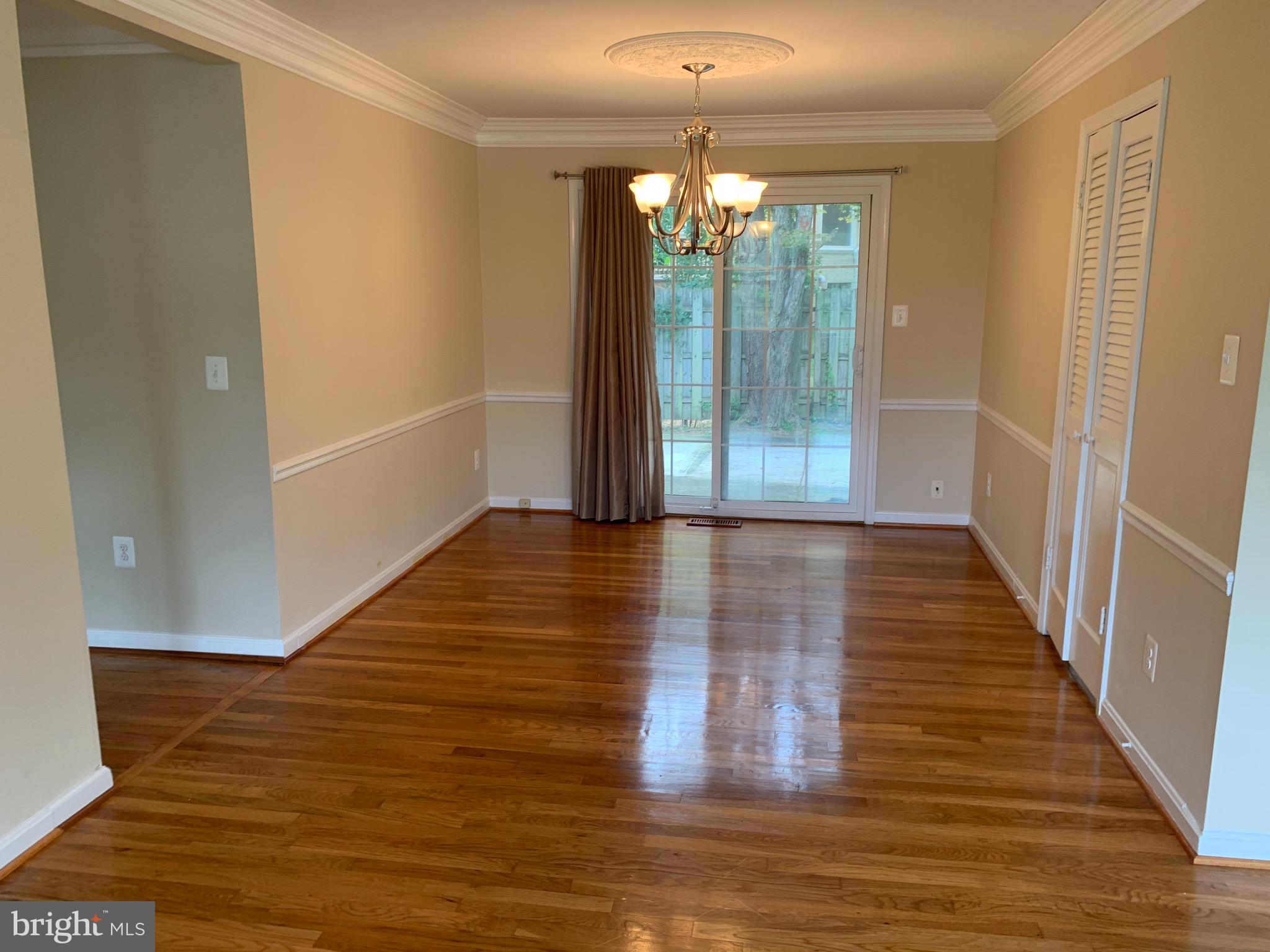 9700 Brookford Road Potomac, MD 20854 - Photo 9 of 27 a view of a hallway with wooden floor and chandelier