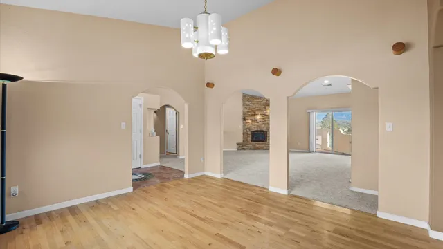 a view of a hallway with wooden floor and chandelier