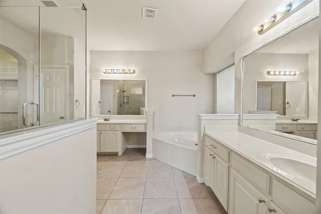 a bathroom with a sink a large mirror and a bathtub