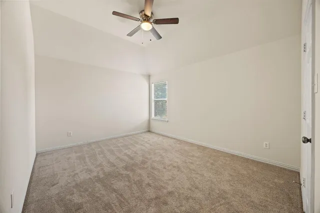 an empty room with a fan and a window