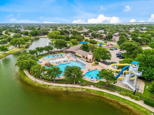 an aerial view of residential houses with outdoor space and lake view