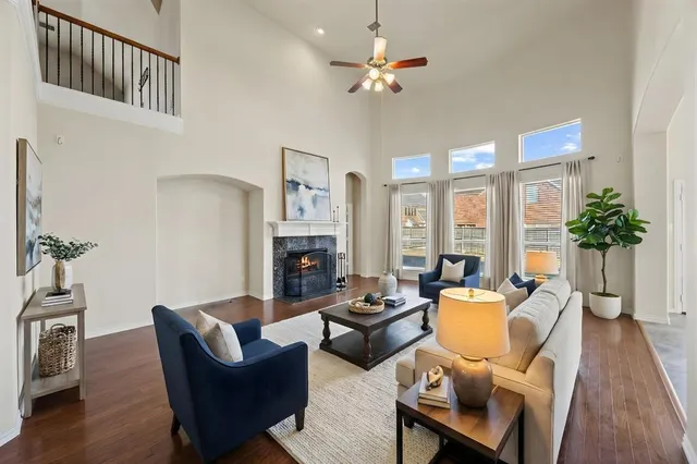 a living room with furniture a fireplace and a chandelier