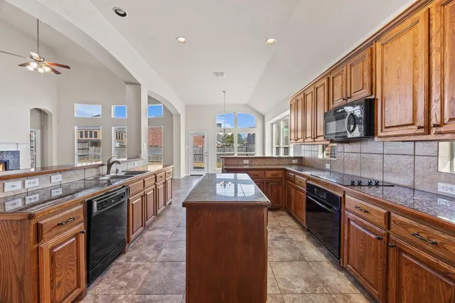 a kitchen with stainless steel appliances granite countertop a stove a sink dishwasher and a refrigerator