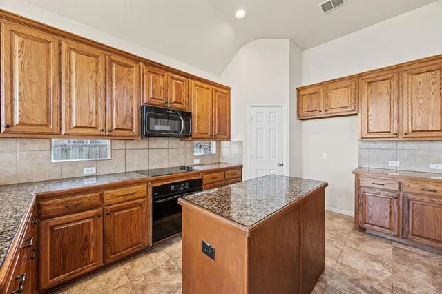 a kitchen with stainless steel appliances granite countertop wooden cabinets and a granite counter tops