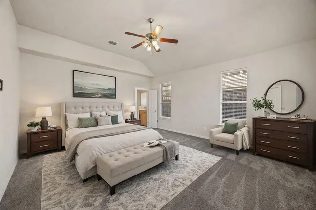 a bedroom with a bed large window and couch