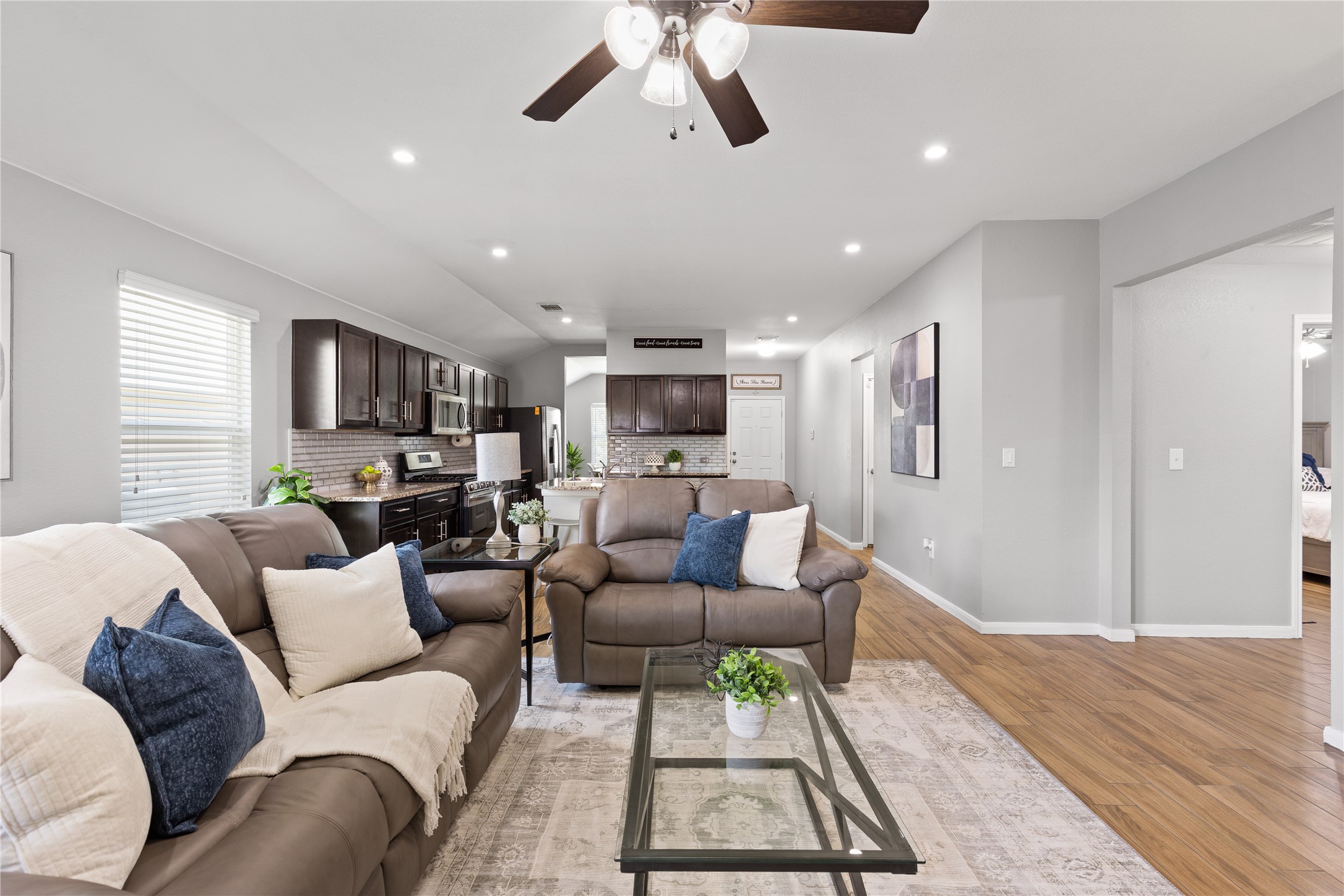 256 Alpha Kyle, TX 78640 - Photo 12 of 27 An open concept living area transitions smoothly into a modern kitchen, ideal for effortless entertaining.
