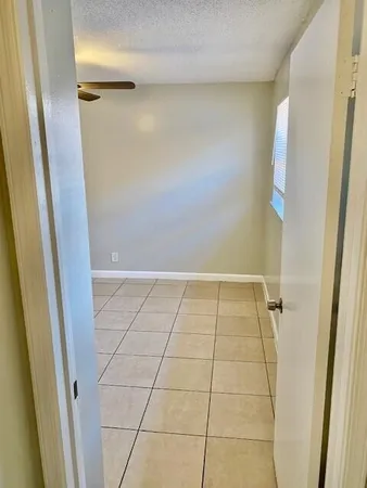 an empty room with windows and fan
