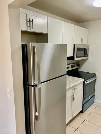 a white refrigerator freezer and a stove in a kitchen