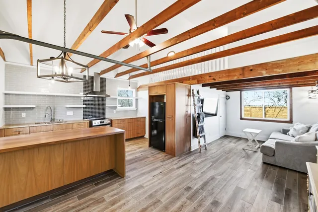 a view of a kitchen with refrigerator and wooden floor