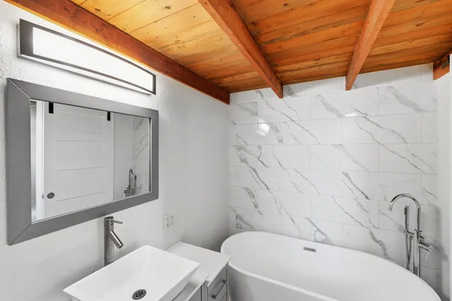 a bathroom with a sink a toilet and mirror